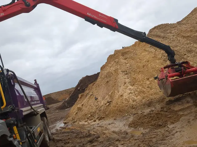 Grab lorry hydraulic arm loading soil on a Winton area job